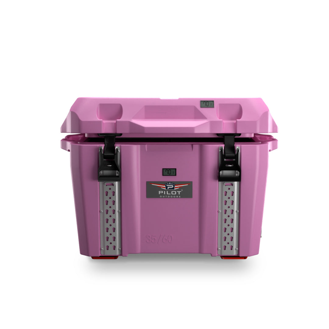 Pilot Outdoors hard‑shell cooler chest in pale pink (blush), shown close-up from a side‑front angle with handle and latch.